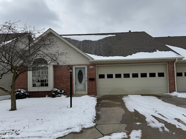 view of front facade featuring a garage, brick siding, and a shingled roof