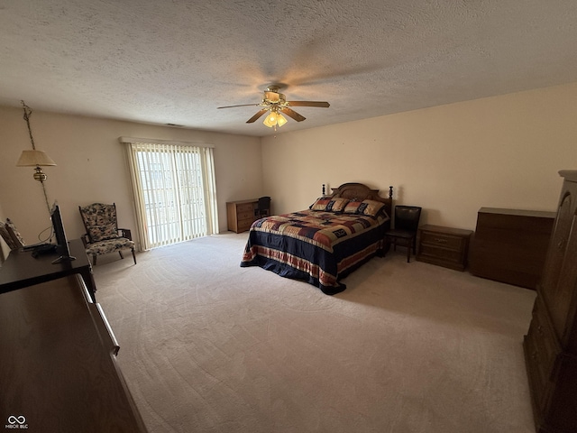 bedroom featuring light carpet, ceiling fan, and a textured ceiling