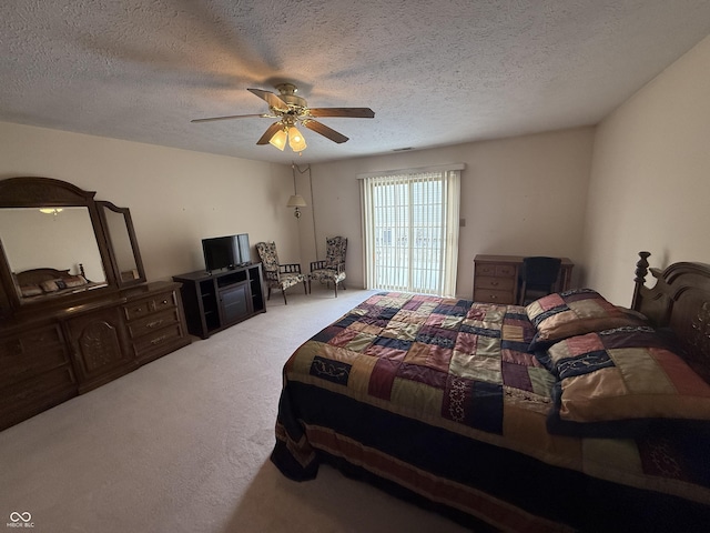 carpeted bedroom with a textured ceiling and a ceiling fan