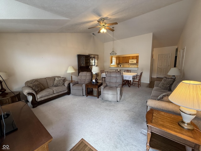 carpeted living room featuring a ceiling fan, high vaulted ceiling, and a textured ceiling