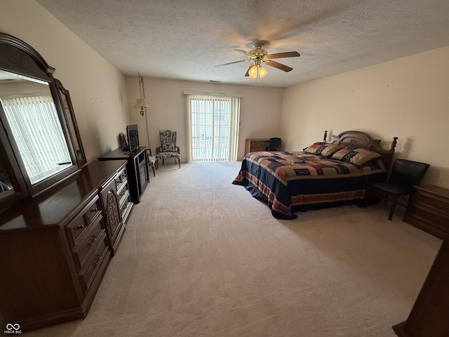 bedroom featuring light carpet, ceiling fan, and a textured ceiling