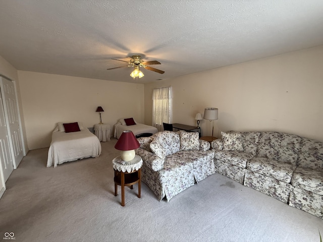 carpeted bedroom with a ceiling fan and a textured ceiling