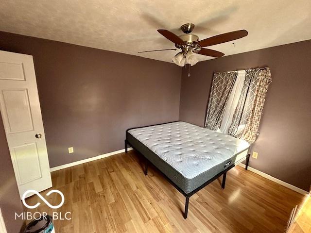 bedroom with hardwood / wood-style floors and ceiling fan