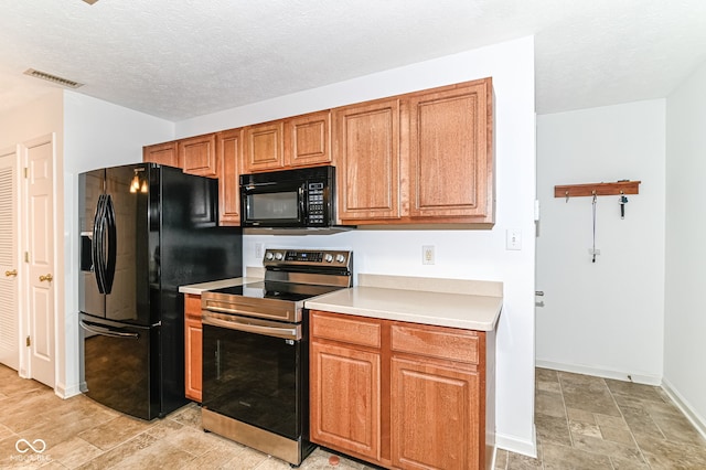 kitchen featuring black appliances, visible vents, light countertops, and brown cabinetry