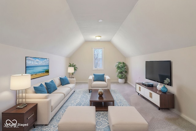 living area featuring baseboards, lofted ceiling, and carpet