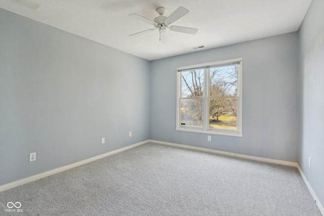 carpeted empty room featuring a ceiling fan, visible vents, and baseboards