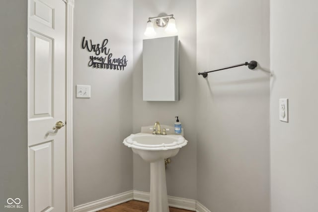 bathroom with baseboards and wood finished floors