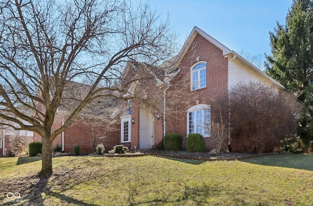 traditional-style house with brick siding and a front yard