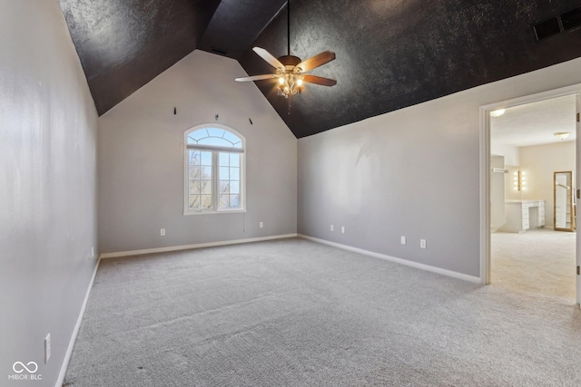 empty room with baseboards, visible vents, lofted ceiling, ceiling fan, and carpet flooring