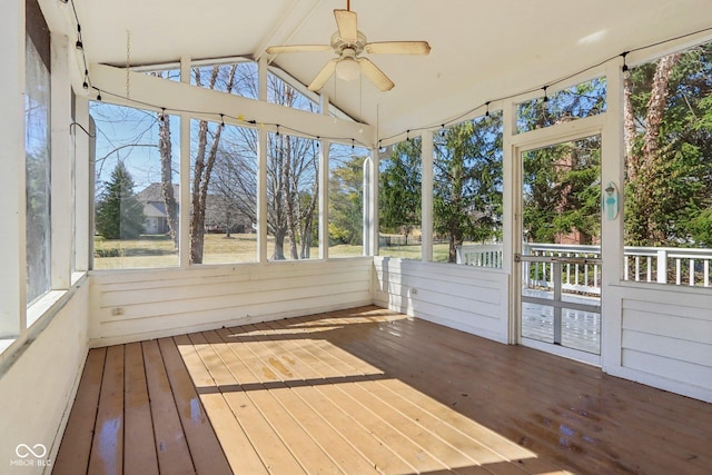 unfurnished sunroom featuring ceiling fan and vaulted ceiling with beams