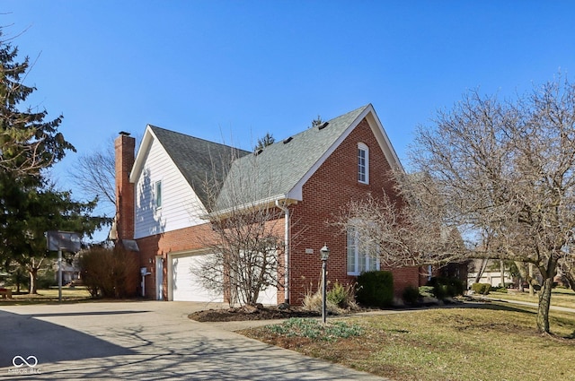 view of home's exterior featuring driveway, a chimney, a garage, a lawn, and brick siding