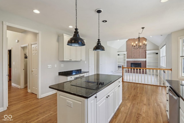 kitchen featuring lofted ceiling, stainless steel dishwasher, light wood-style flooring, and white cabinets