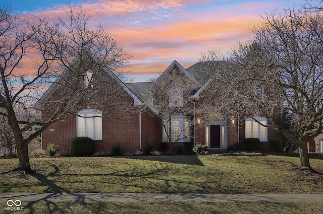 view of front of home with a front lawn and brick siding