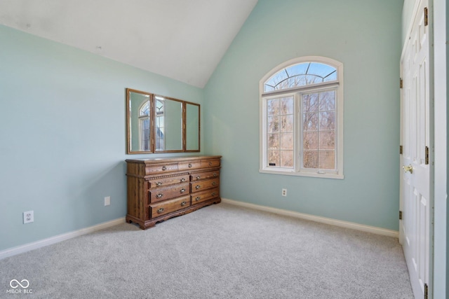 carpeted bedroom with baseboards and high vaulted ceiling