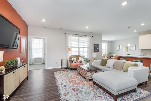 living area featuring a wealth of natural light, dark wood-style flooring, baseboards, and recessed lighting