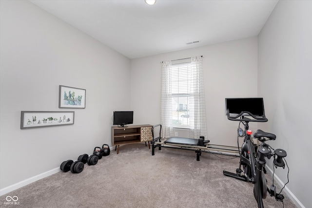 workout area featuring baseboards, visible vents, and carpet flooring