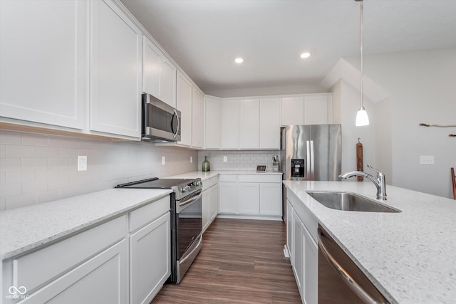 kitchen with tasteful backsplash, appliances with stainless steel finishes, white cabinets, and a sink