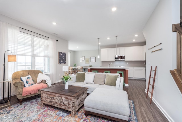 living room featuring dark wood-style floors, recessed lighting, and baseboards