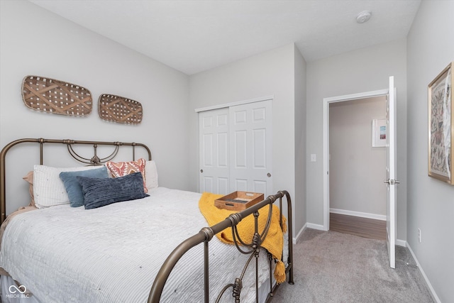 bedroom with light carpet, baseboards, and a closet