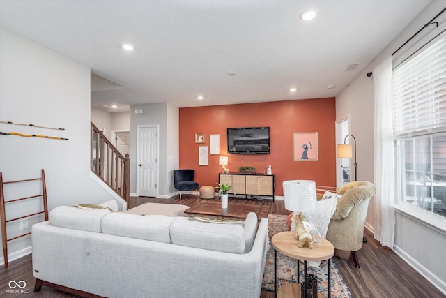 living room featuring baseboards, stairway, wood finished floors, and recessed lighting