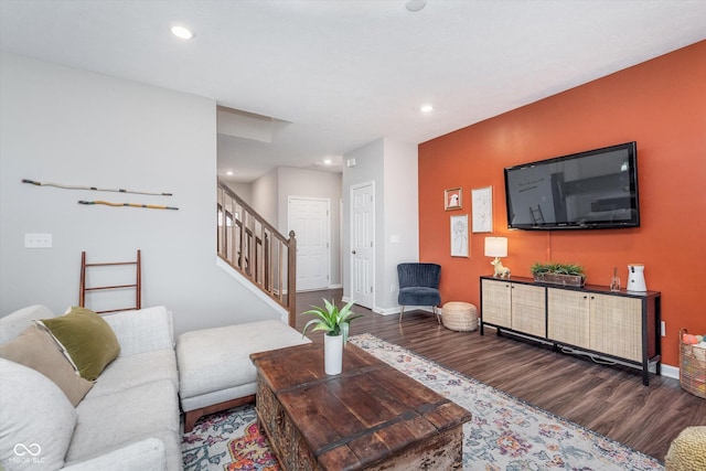 living room featuring baseboards, stairway, wood finished floors, and recessed lighting