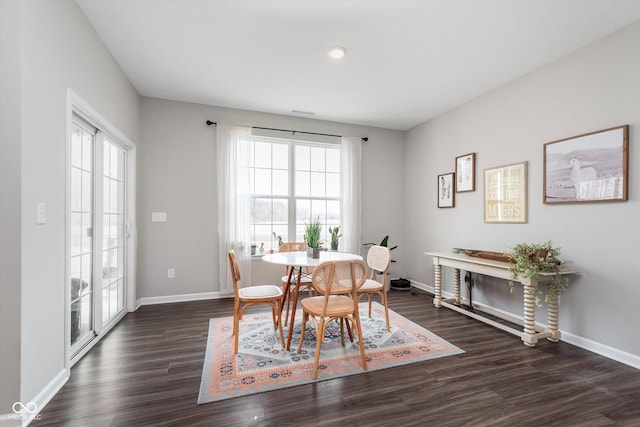 dining space featuring dark wood-style floors and baseboards