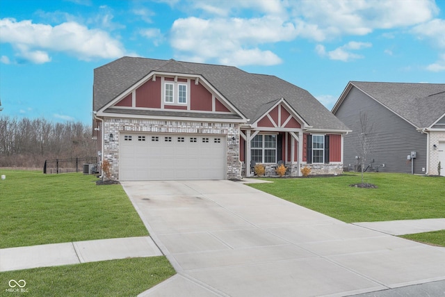 craftsman inspired home featuring roof with shingles, a front yard, central AC, and concrete driveway