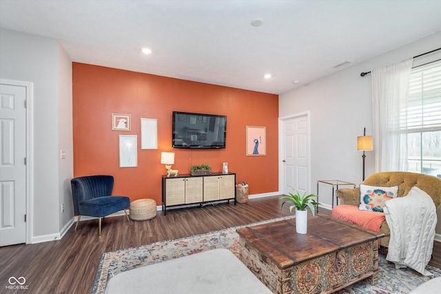 living area with recessed lighting, wood finished floors, visible vents, and baseboards