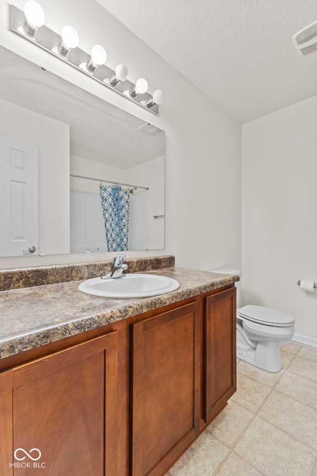 bathroom featuring tile patterned flooring, a shower with shower curtain, vanity, a textured ceiling, and toilet