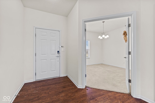 entrance foyer with dark hardwood / wood-style flooring and an inviting chandelier