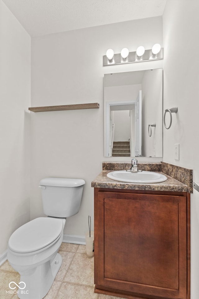 bathroom with vanity, toilet, and tile patterned flooring