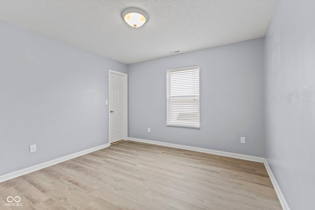 unfurnished room featuring a textured ceiling and light wood-type flooring