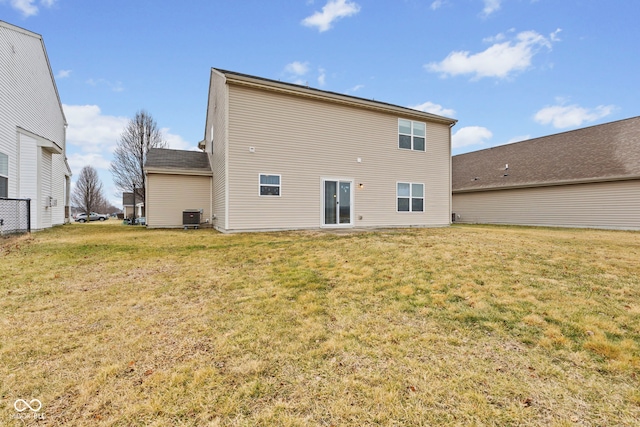 back of property featuring cooling unit and a lawn