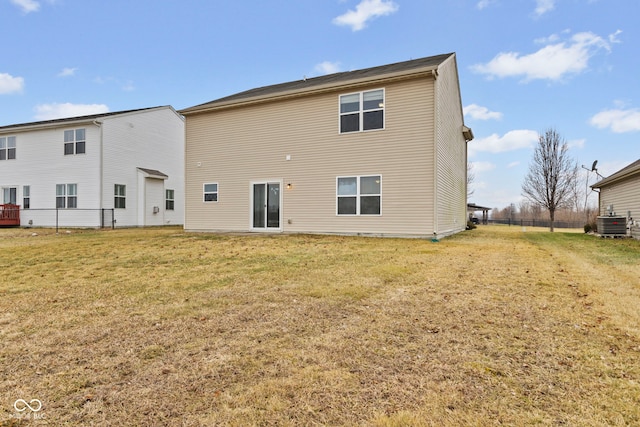 rear view of property with a yard and central AC unit