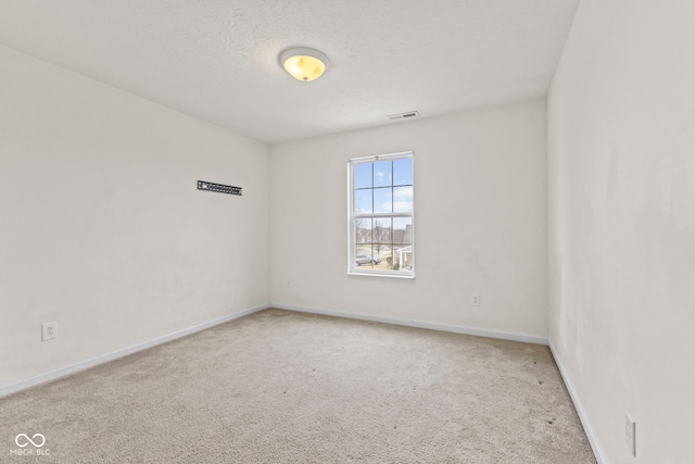 carpeted empty room with a textured ceiling