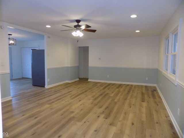 empty room with light hardwood / wood-style flooring and ceiling fan