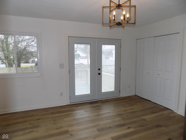 doorway with french doors, dark hardwood / wood-style floors, and a notable chandelier