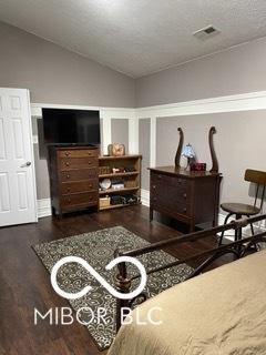 bedroom featuring visible vents, baseboards, vaulted ceiling, and wood finished floors