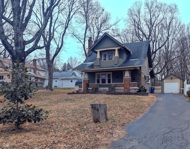 view of front facade featuring a garage, an outdoor structure, and a porch