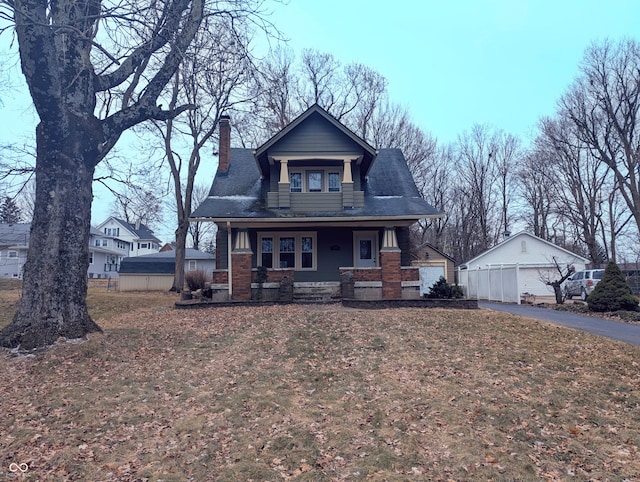 view of front facade with a garage, an outdoor structure, and covered porch