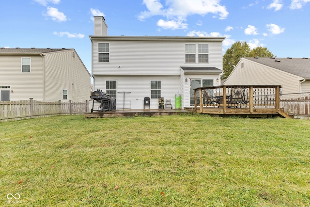 back of property featuring a deck and a lawn