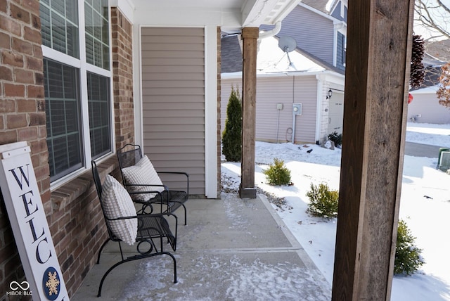 snow covered patio with a porch