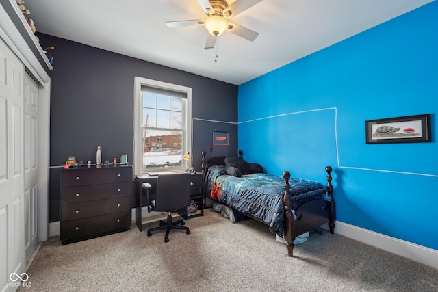 carpeted bedroom with ceiling fan, baseboards, and a closet