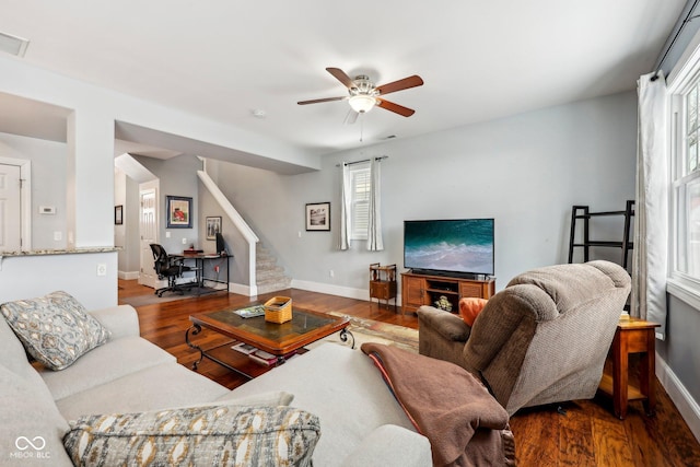 living room with stairs, wood finished floors, a ceiling fan, and baseboards