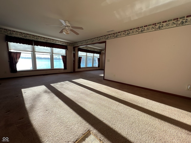 empty room with dark carpet and ceiling fan