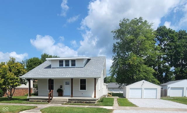 bungalow-style house with a garage, a front yard, an outbuilding, and covered porch