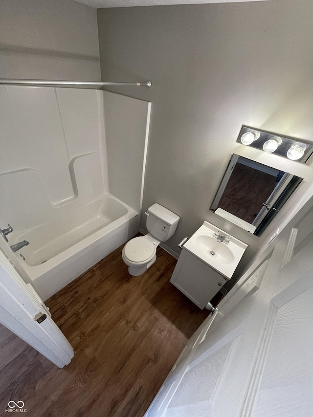 full bathroom with vanity, hardwood / wood-style flooring, toilet, and washtub / shower combination