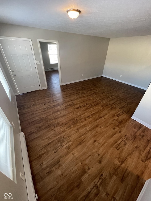 spare room featuring dark hardwood / wood-style floors and a textured ceiling