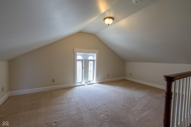 bonus room featuring baseboards, light carpet, and lofted ceiling