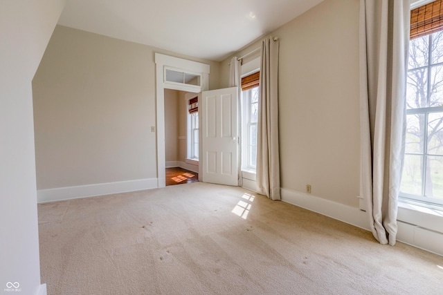 unfurnished bedroom with baseboards, multiple windows, and carpet floors